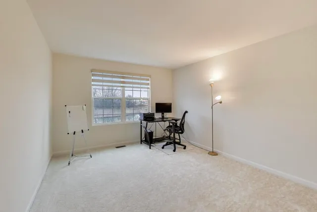 a view of a workspace with furniture and a window