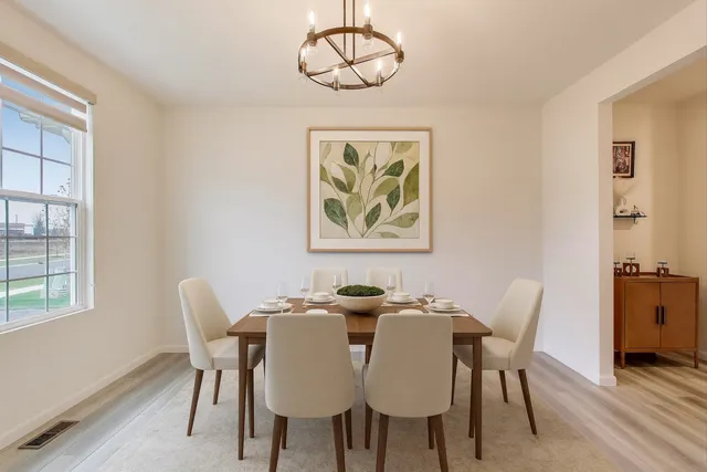 a dining room with furniture a window and wooden floor