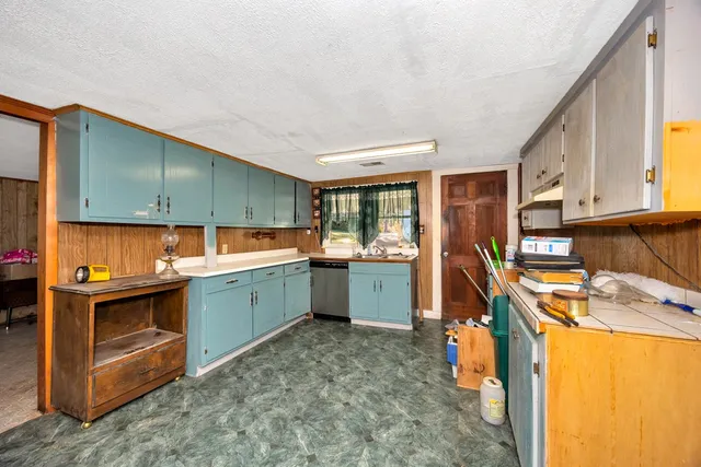 a kitchen with a sink a stove and cabinets