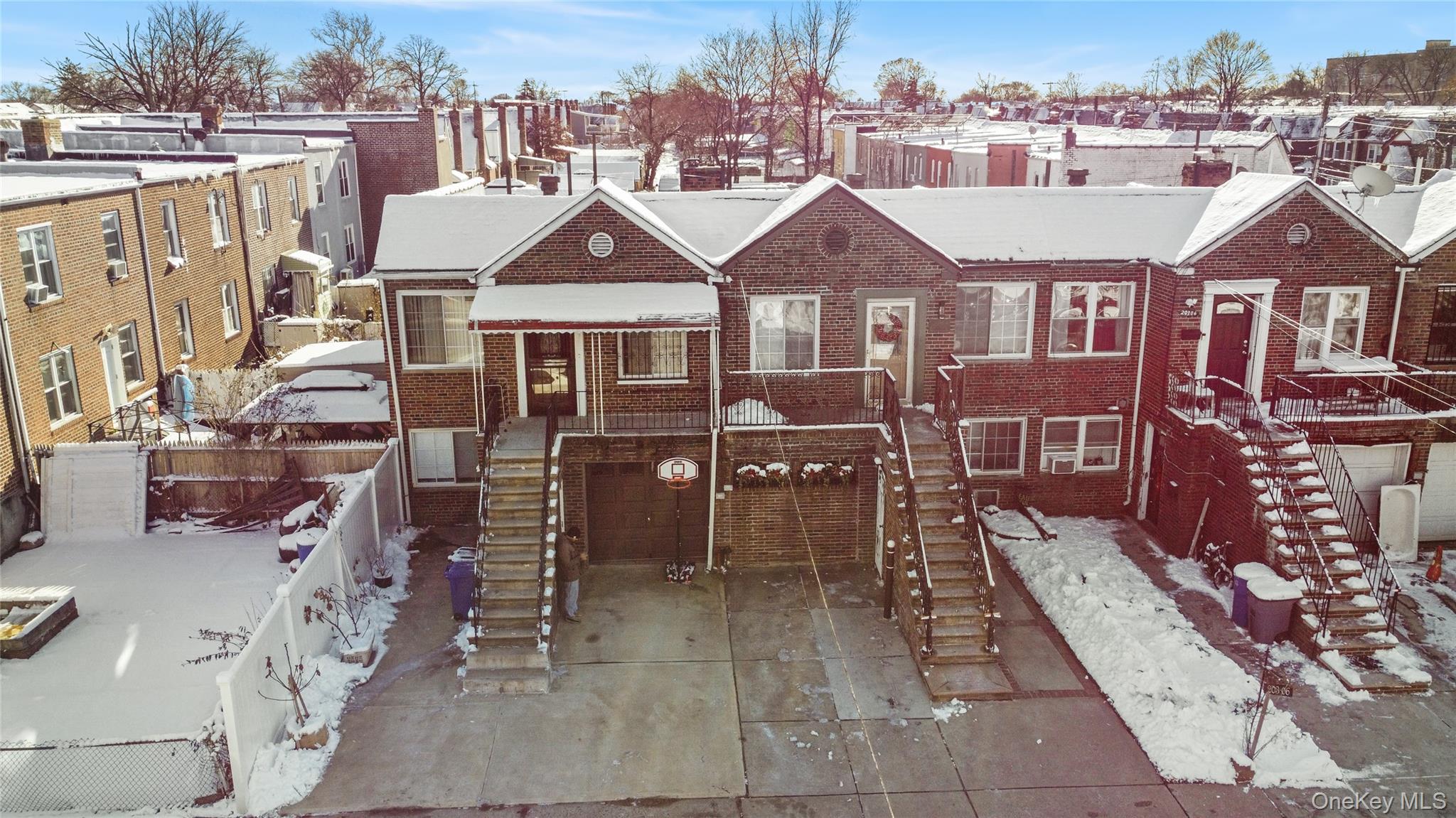 View of front facade with stairs, a garage, and driveway