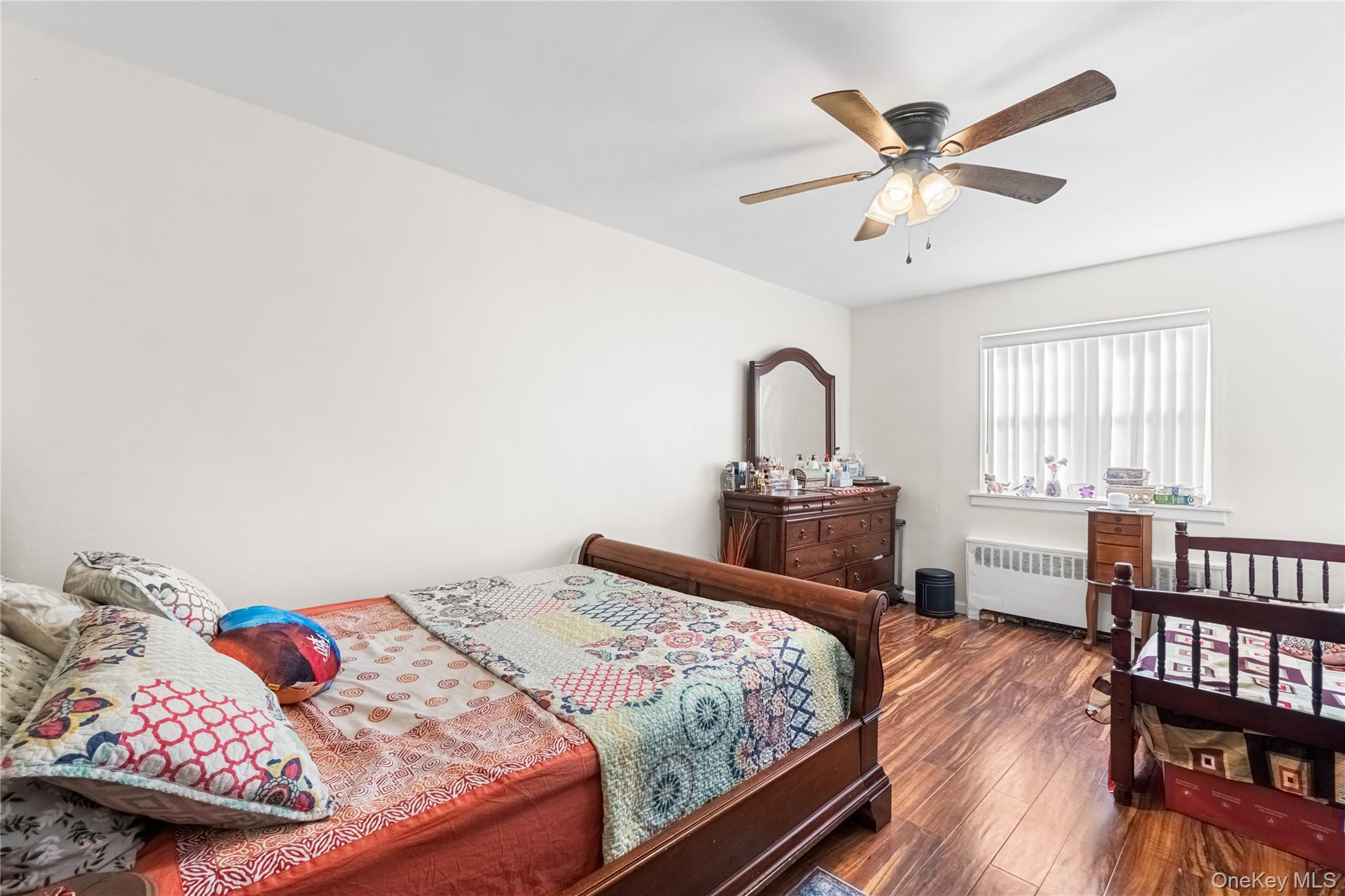 203-10 Murdock Avenue Queens, NY 11412 - Photo 14 of 18 Bedroom featuring dark wood-style floors, ceiling fan, and radiator