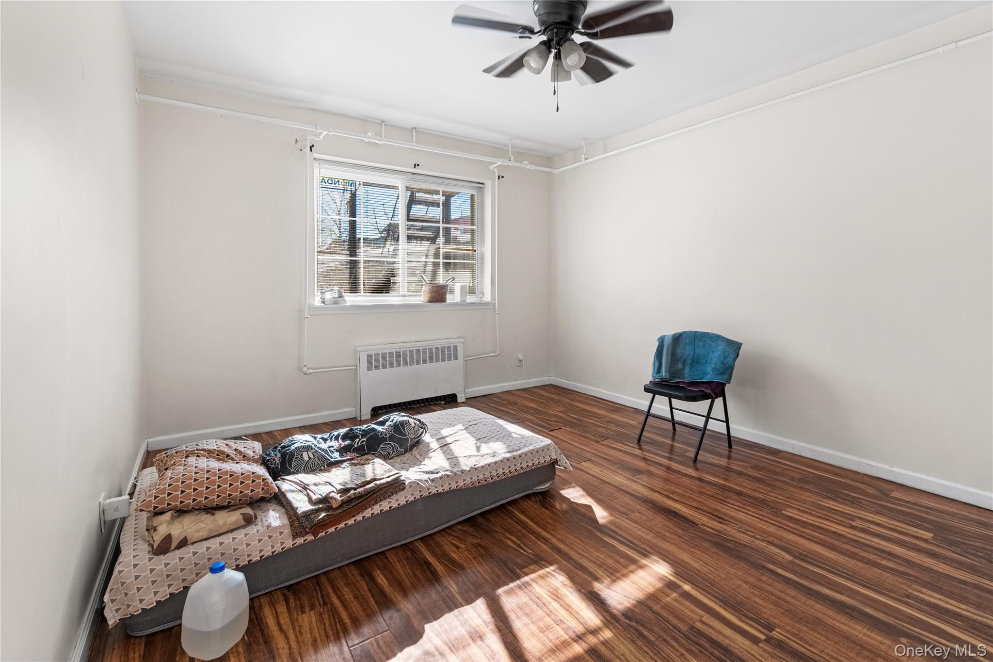203-10 Murdock Avenue Queens, NY 11412 - Photo 8 of 18 Sitting room featuring radiator heating unit, ceiling fan, and dark wood-style floors