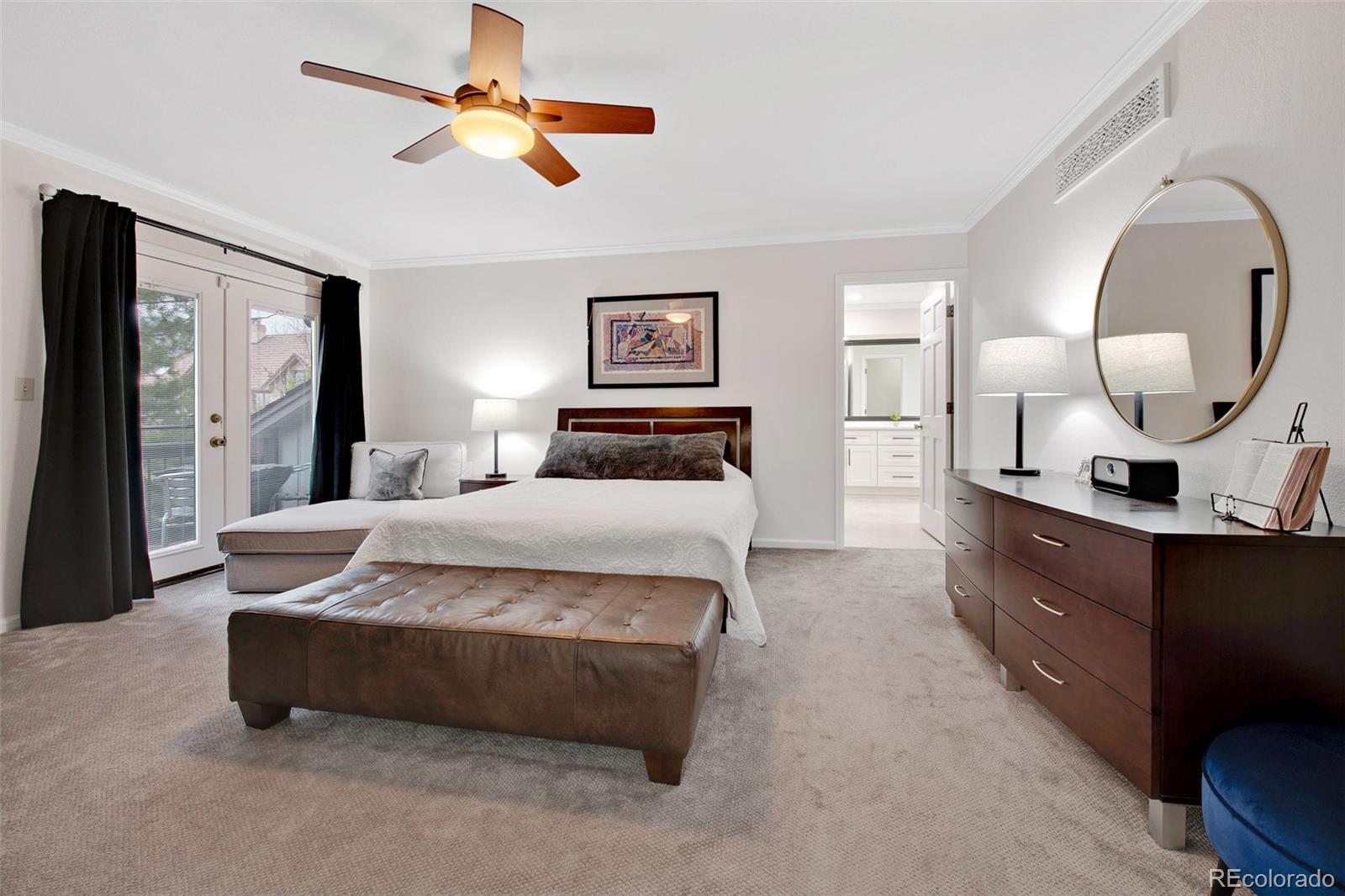 4 Mule Deer Trail Littleton, CO 80127 - Photo 20 of 40 a spacious bedroom with a bed a mirror and a large window