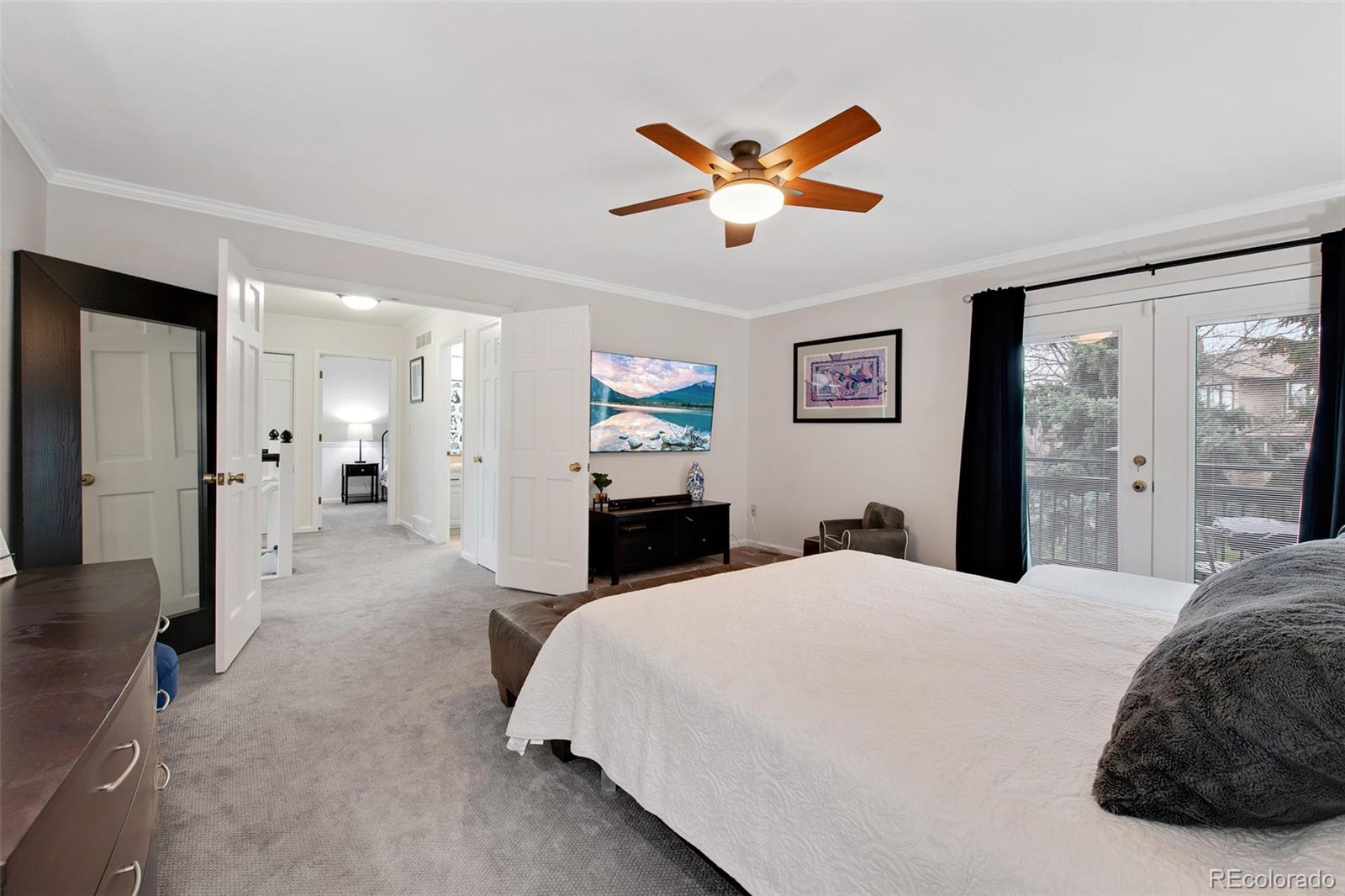 4 Mule Deer Trail Littleton, CO 80127 - Photo 21 of 40 a bed room with a bed and a chandelier