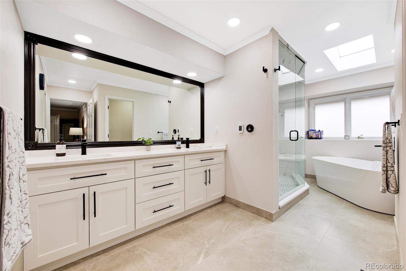 4 Mule Deer Trail Littleton, CO 80127 - Photo 22 of 40 a spacious bathroom with a double vanity sink mirror and bathtub