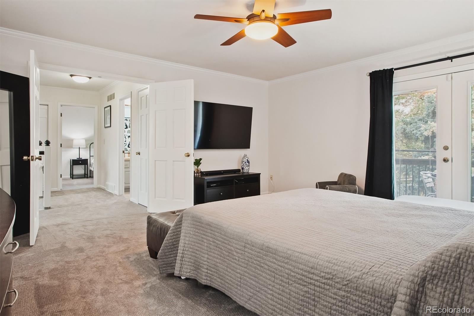 4 Mule Deer Trail Littleton, CO 80127 - Photo 30 of 40 a spacious bedroom with a bed and a flat screen tv