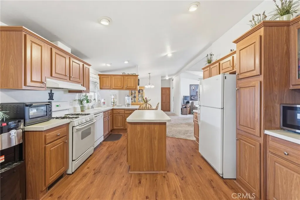 20843 Waalew Road, Unit C48 Apple Valley, CA 92307 - Photo 12 of 33 a kitchen with kitchen island wooden floors appliances and cabinets