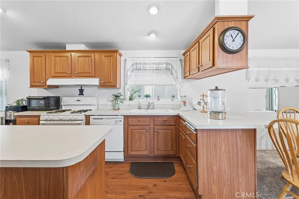 20843 Waalew Road, Unit C48 Apple Valley, CA 92307 - Photo 14 of 33 a kitchen with stainless steel appliances granite countertop a sink a stove a refrigerator cabinets and chairs