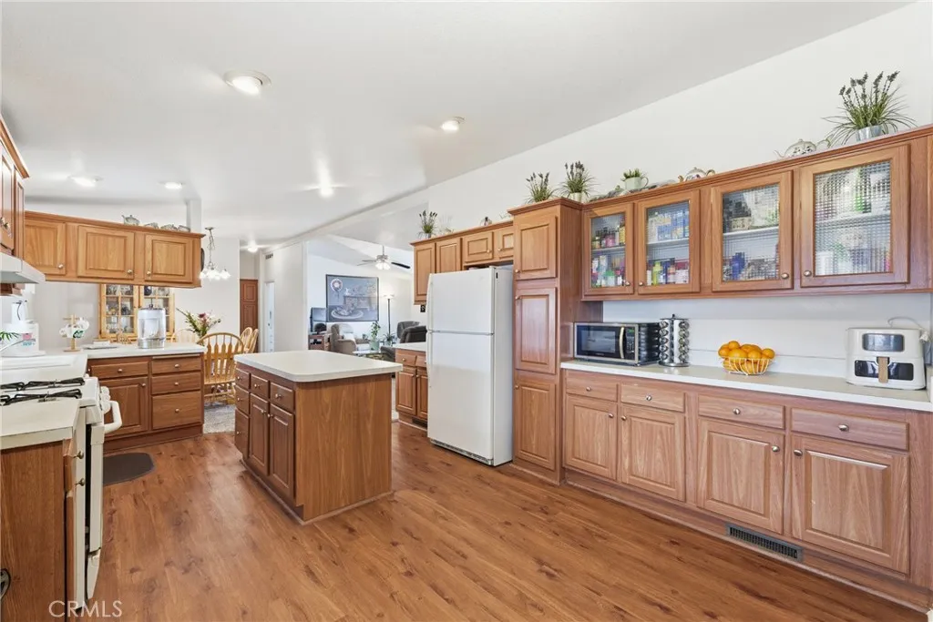 20843 Waalew Road, Unit C48 Apple Valley, CA 92307 - Photo 15 of 33 a kitchen with stainless steel appliances granite countertop a refrigerator a stove a sink dishwasher and wooden cabinets with wooden floor