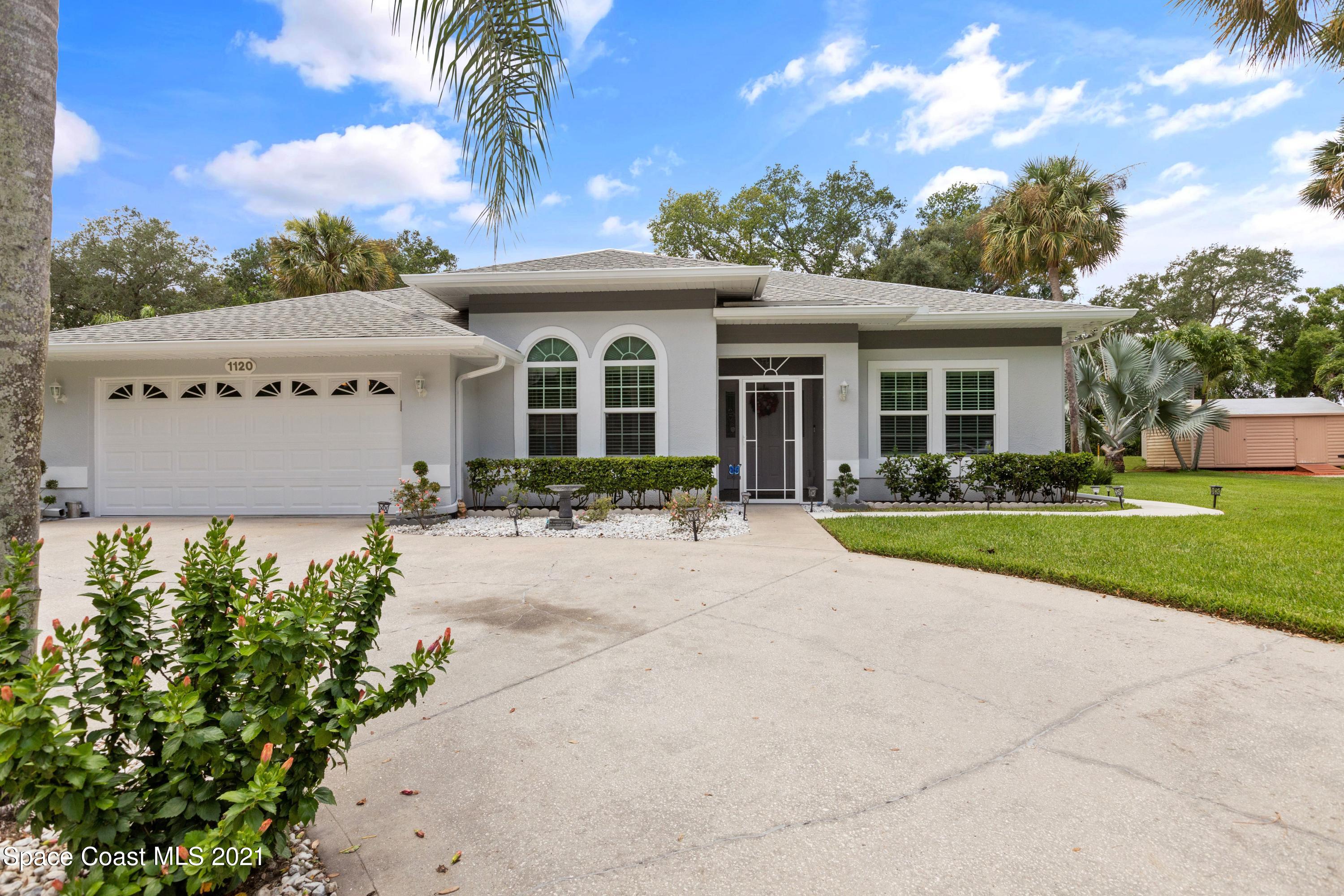 1120 Meadowbrook Road Northeast Palm Bay, FL 32905 - Photo 1 of 33 front view of a house with a yard