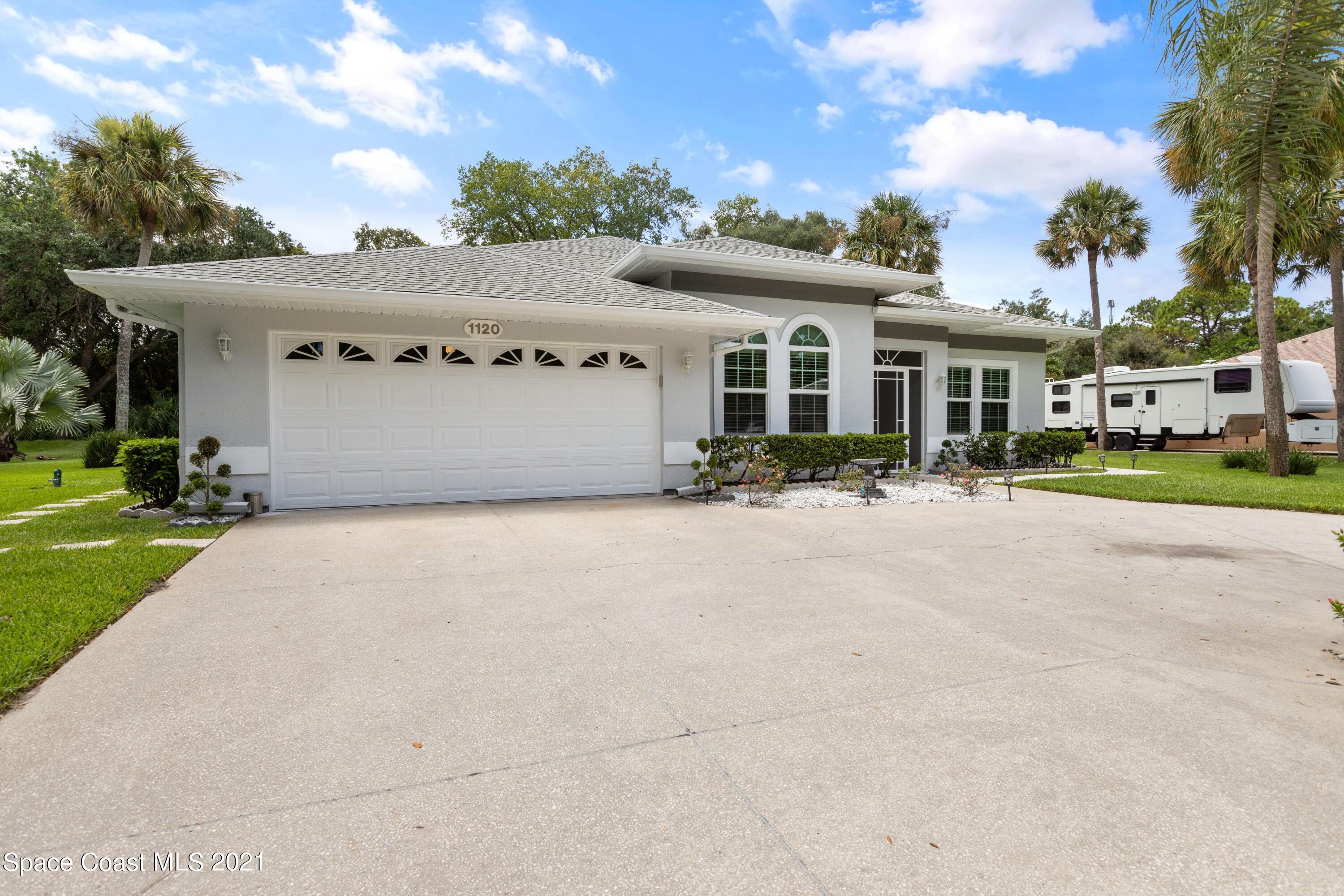 1120 Meadowbrook Road Northeast Palm Bay, FL 32905 - Photo 2 of 33 front view of house with potted plants
