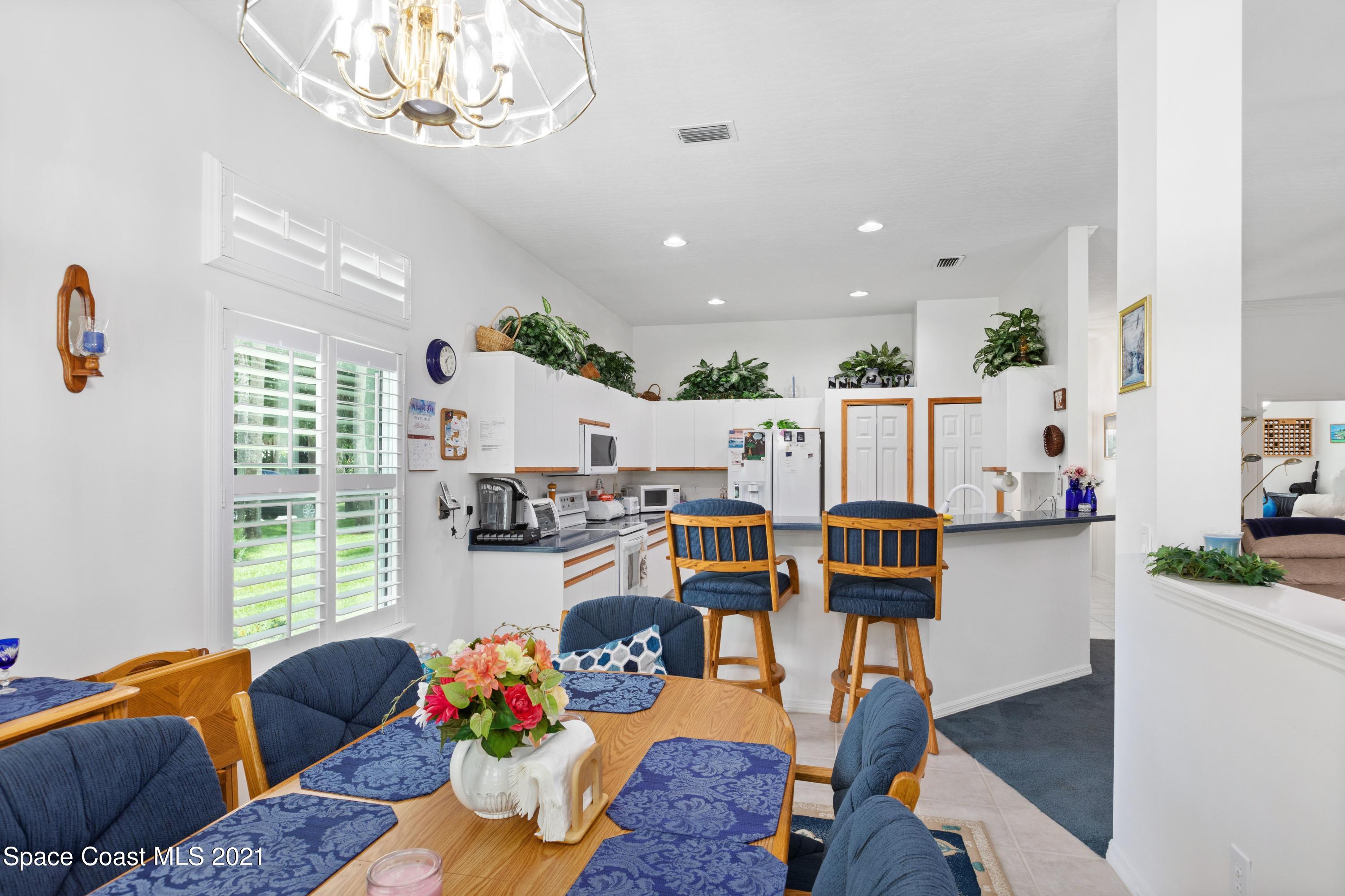 1120 Meadowbrook Road Northeast Palm Bay, FL 32905 - Photo 11 of 33 a living room with furniture and a chandelier
