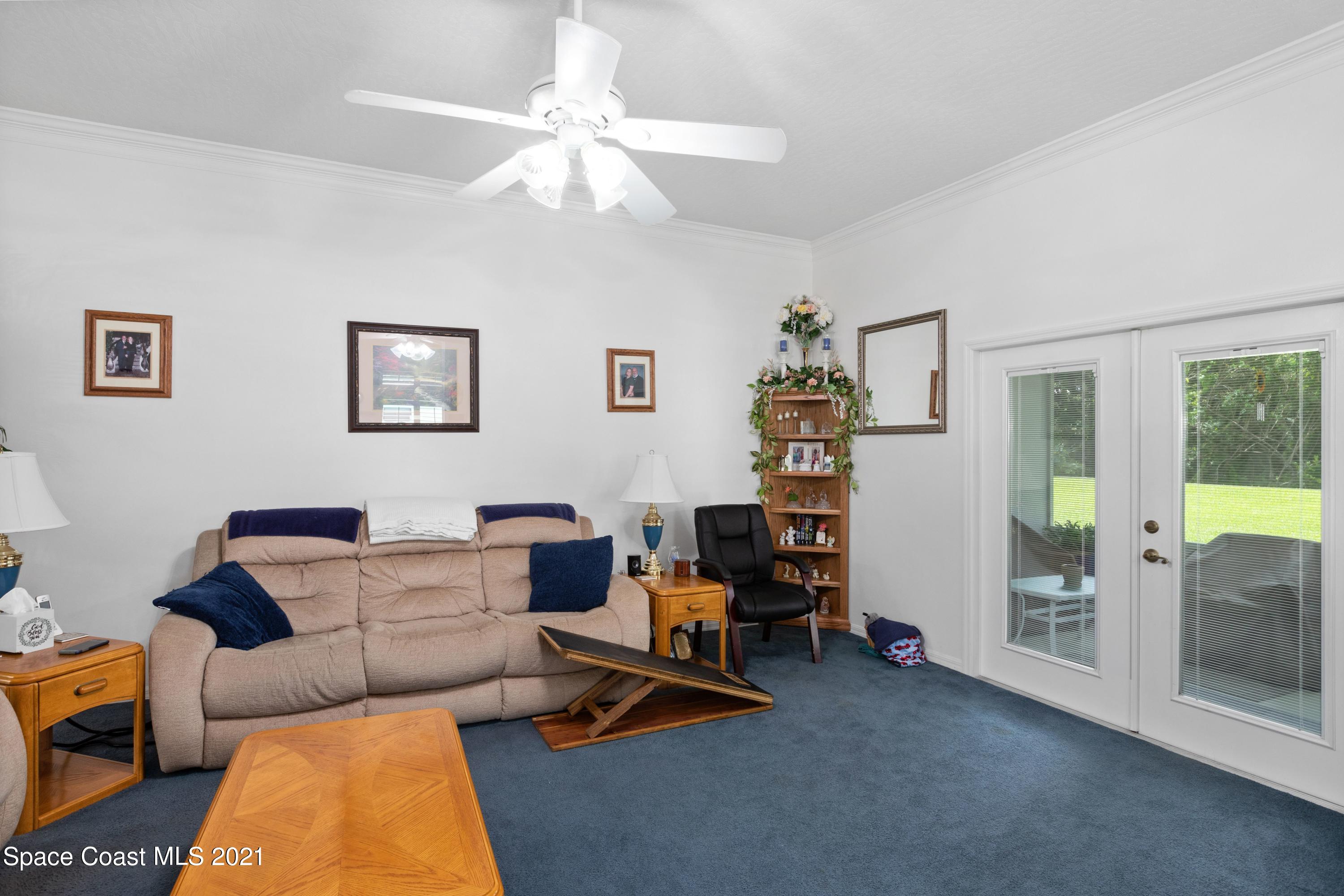 1120 Meadowbrook Road Northeast Palm Bay, FL 32905 - Photo 16 of 33 a living room with furniture a table and a chandelier