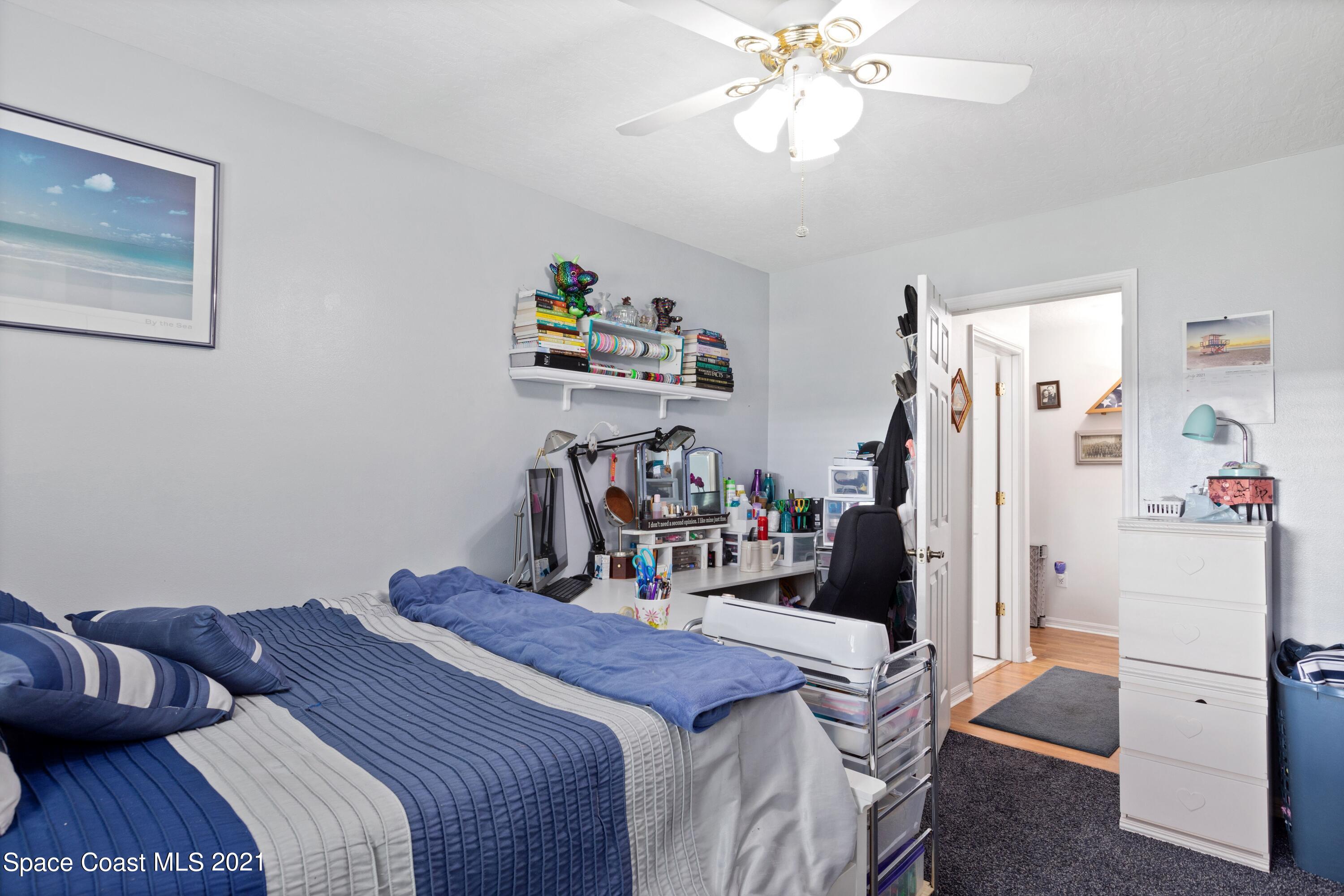 1120 Meadowbrook Road Northeast Palm Bay, FL 32905 - Photo 22 of 33 a bedroom with a bed and a chandelier
