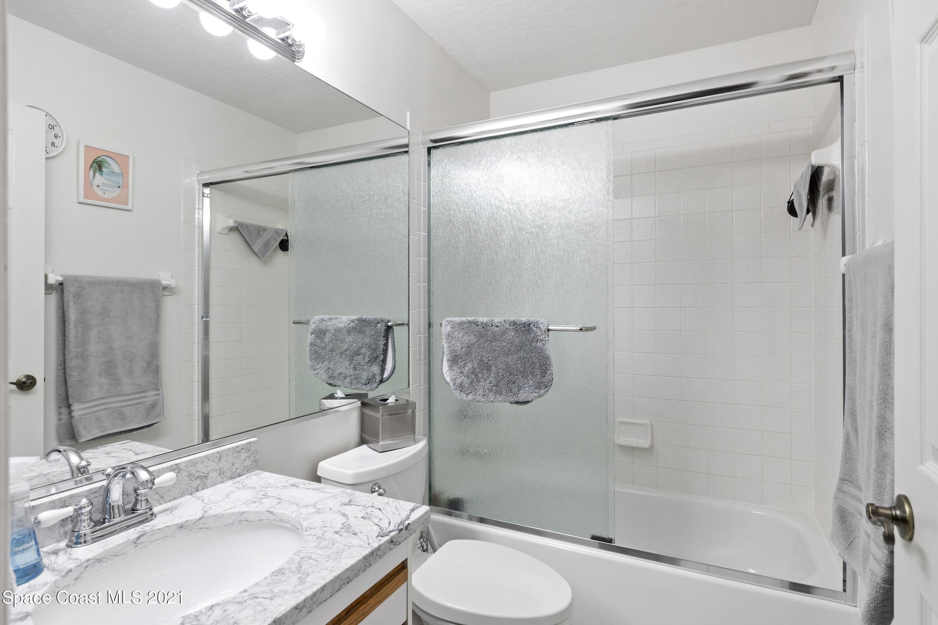 1120 Meadowbrook Road Northeast Palm Bay, FL 32905 - Photo 26 of 33 a bathroom with a granite countertop shower sink and toilet