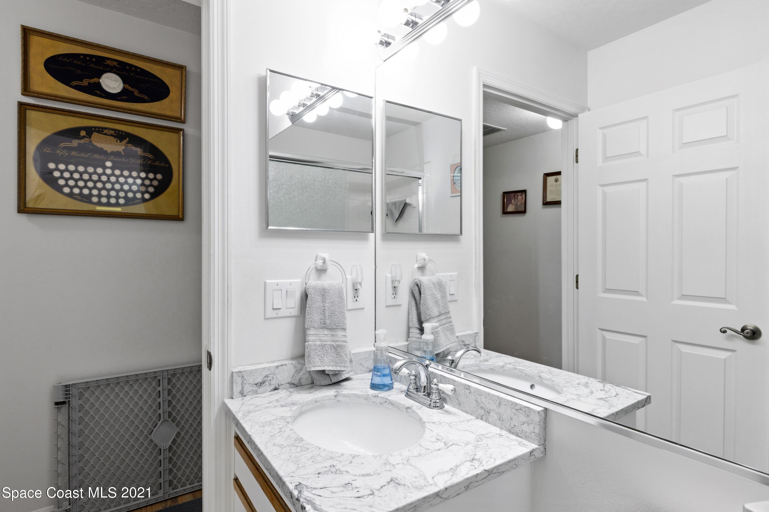 1120 Meadowbrook Road Northeast Palm Bay, FL 32905 - Photo 27 of 33 a bathroom with a sink and a mirror