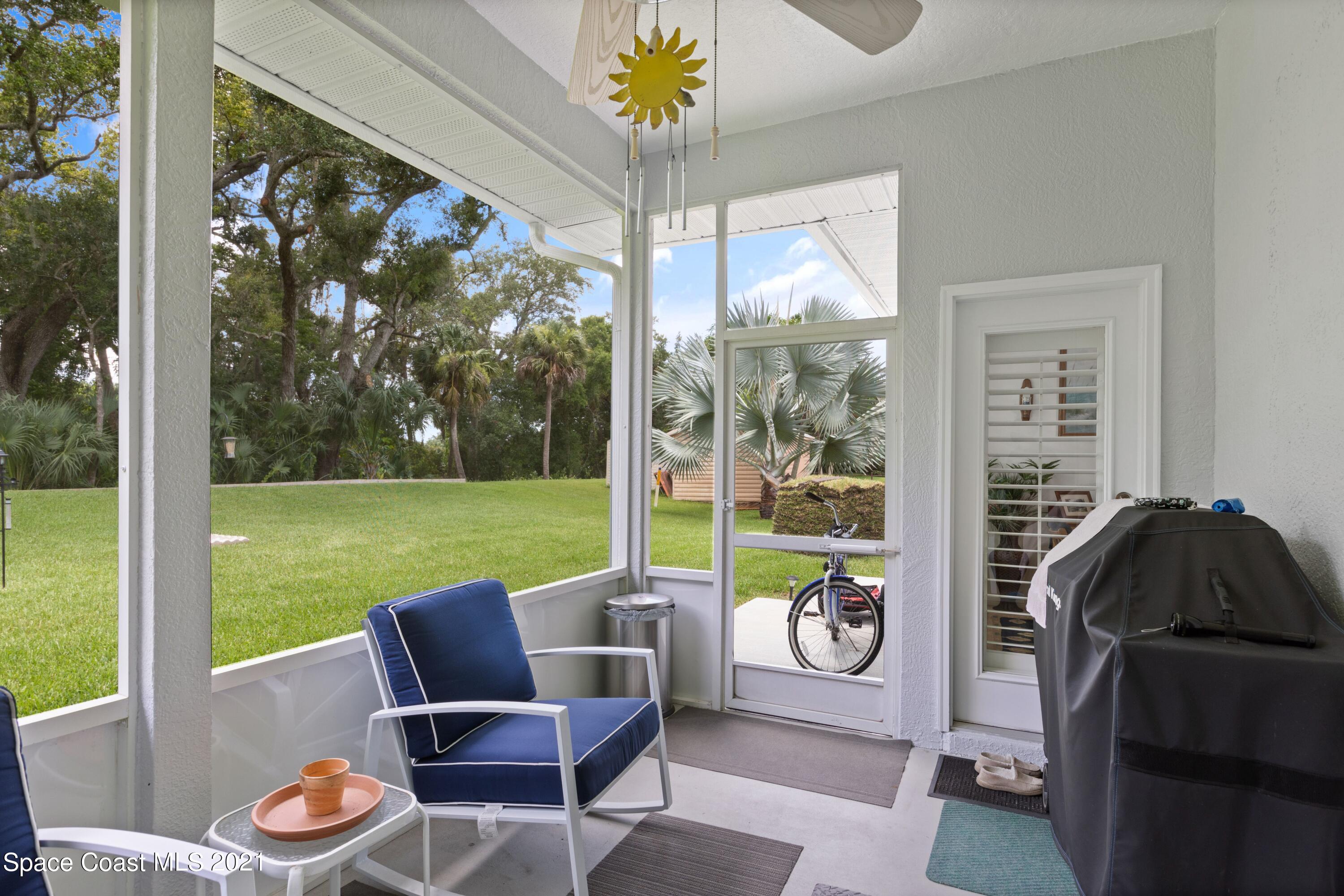 1120 Meadowbrook Road Northeast Palm Bay, FL 32905 - Photo 30 of 33 a living room with patio furniture and a floor to ceiling window