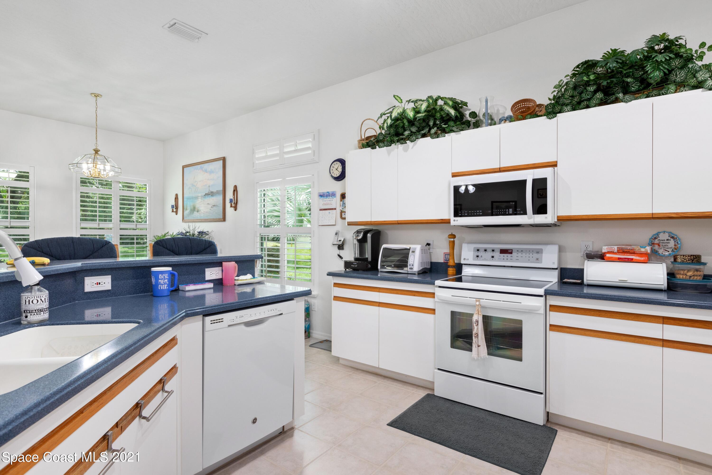 1120 Meadowbrook Road Northeast Palm Bay, FL 32905 - Photo 10 of 33 a kitchen with stainless steel appliances white cabinets a sink and a stove
