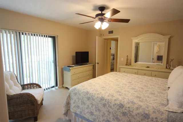 a bedroom with a large bed a flat tv screen and a dresser