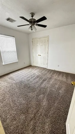 an empty room with windows and fan