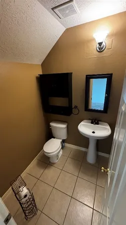 a bathroom with a toilet a sink and mirror