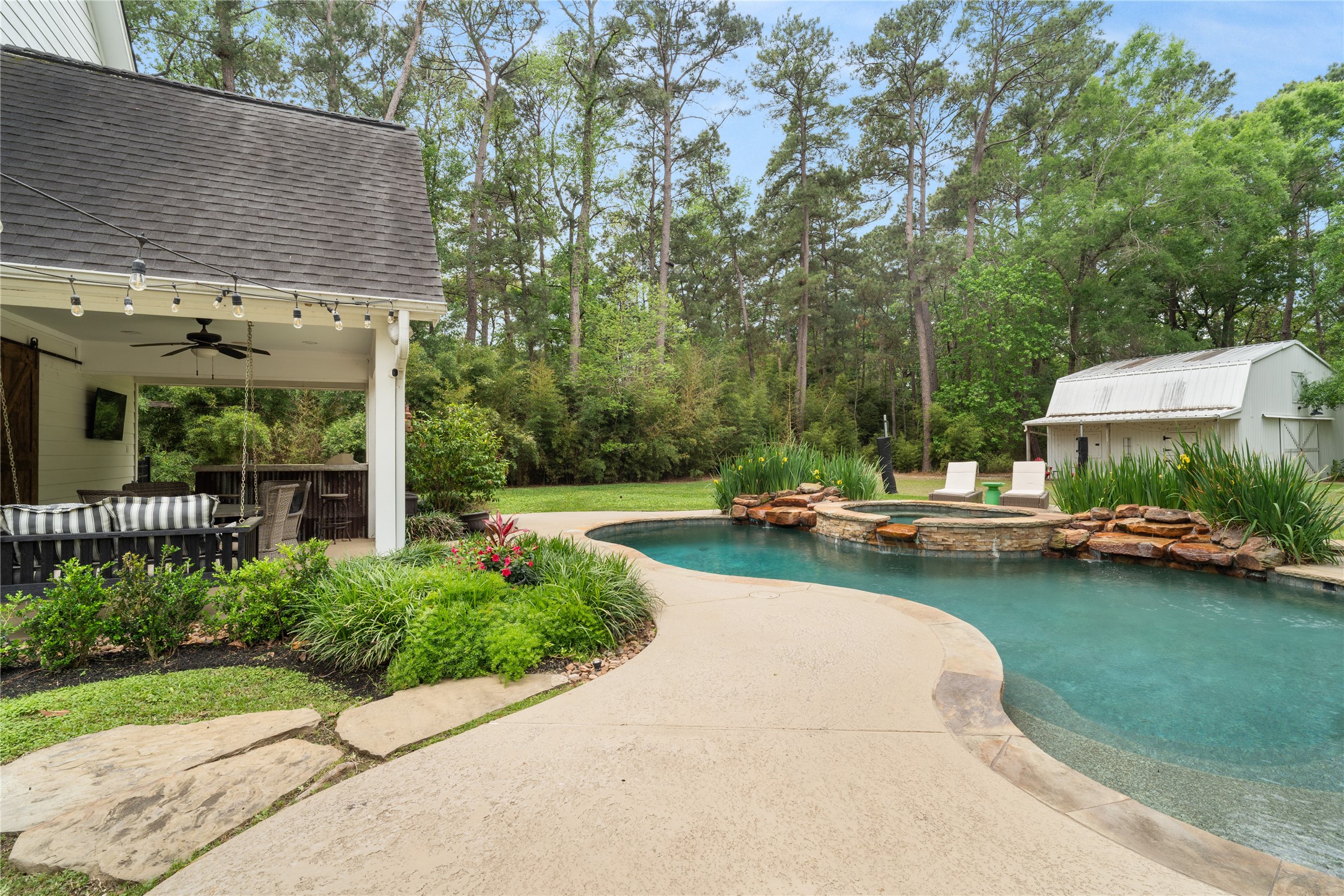 36 Wind River Drive Conroe, TX 77384 - Photo 16 of 45 Another swing and plenty of room for a patio table to find comfort while a meal is prepared in the outdoor kitchen.