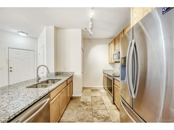 a kitchen with granite countertop a sink stove and cabinets
