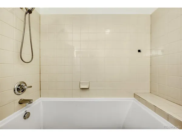 a bathroom with a granite countertop sink a mirror and a bathtub