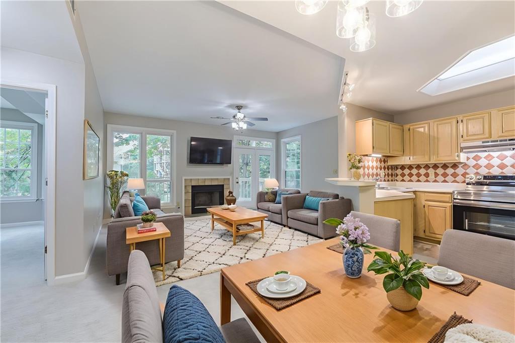 a living room with furniture kitchen view and a large window