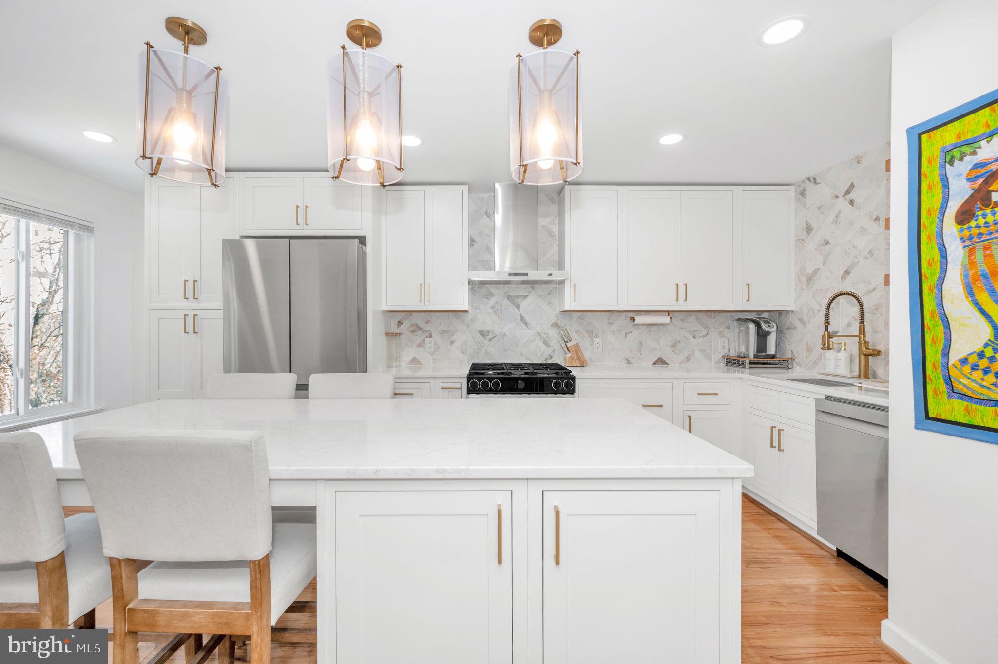 a kitchen with a sink a stove a refrigerator and a dining table with wooden floor