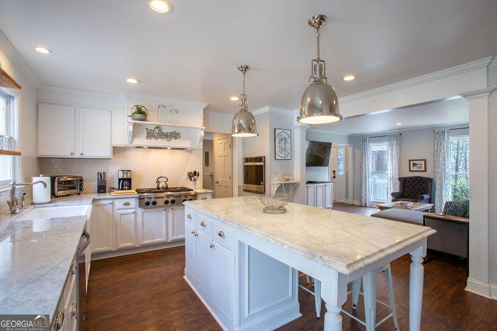 a open kitchen with stainless steel appliances granite countertop a stove oven and a refrigerator