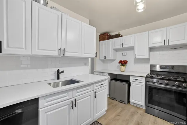 a kitchen with white cabinets and appliances
