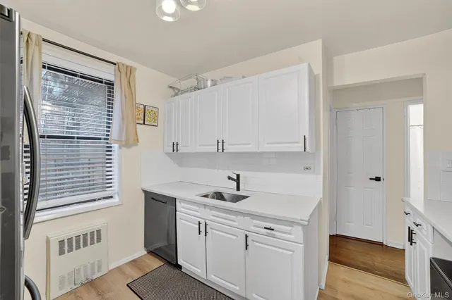 a kitchen with a sink cabinets and a window