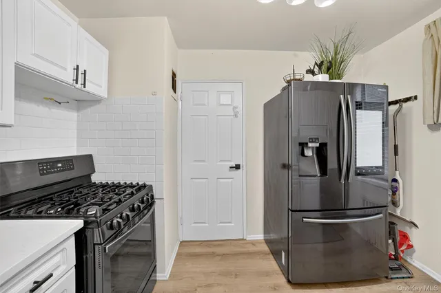 a kitchen with stainless steel appliances granite countertop a refrigerator and a stove