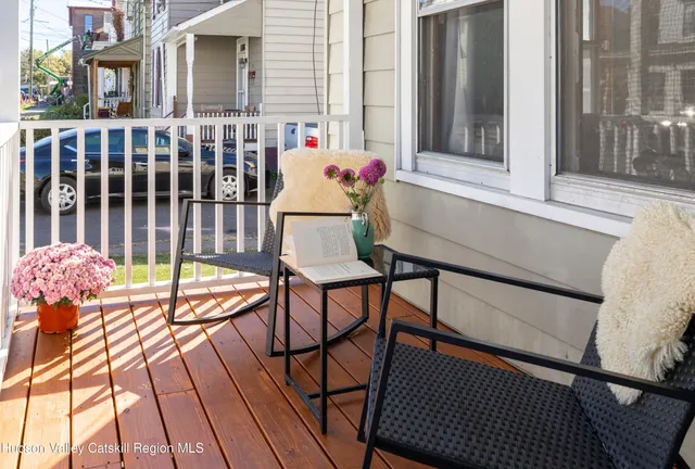 a balcony with table and chairs and wooden floor
