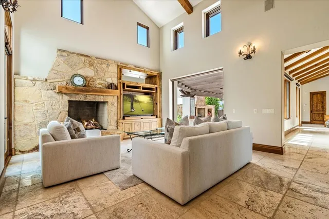 a living room with couches and a dining table with a large kitchen view