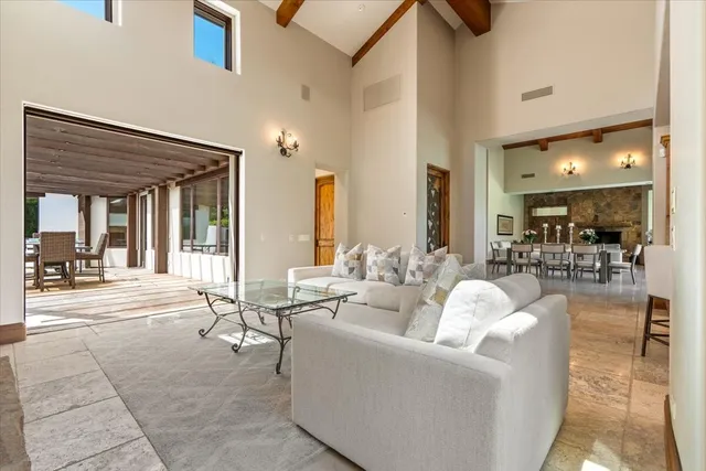 a view of a patio with table and chairs potted plants with floor to ceiling window and potted plants