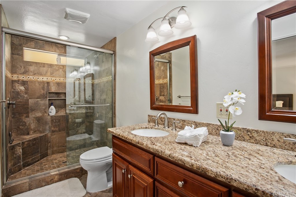 13019 Adah Lane Poway, CA 92064 - Photo 20 of 34 a bathroom with a granite countertop sink a toilet and shower