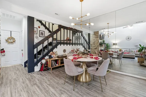 a view of a dining room with furniture a rug and wooden floor
