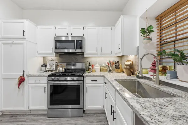 a kitchen with stainless steel appliances granite countertop a sink stove and cabinets
