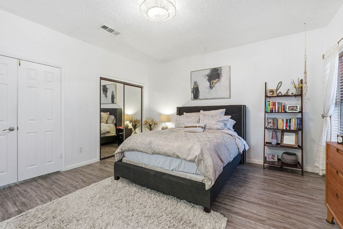 10819 Crown Colony Drive, Unit 33 Austin, TX 78747 - Photo 20 of 27 a bedroom with a bed and a book shelf