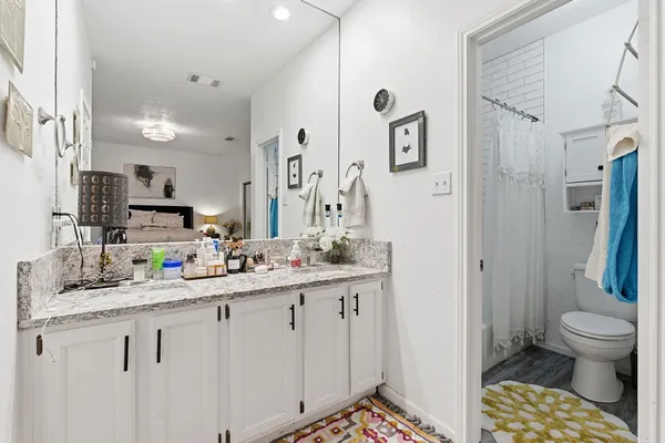 a bathroom with a double vanity sink toilet and shower