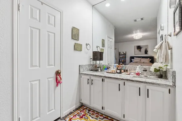 a kitchen with white cabinets and sink