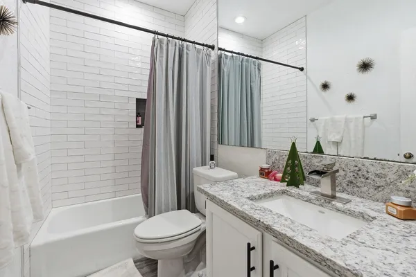 a bathroom with a granite countertop sink toilet and shower