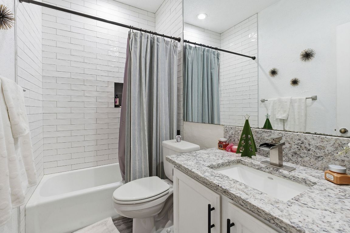 10819 Crown Colony Drive, Unit 33 Austin, TX 78747 - Photo 24 of 27 a bathroom with a granite countertop sink toilet and shower