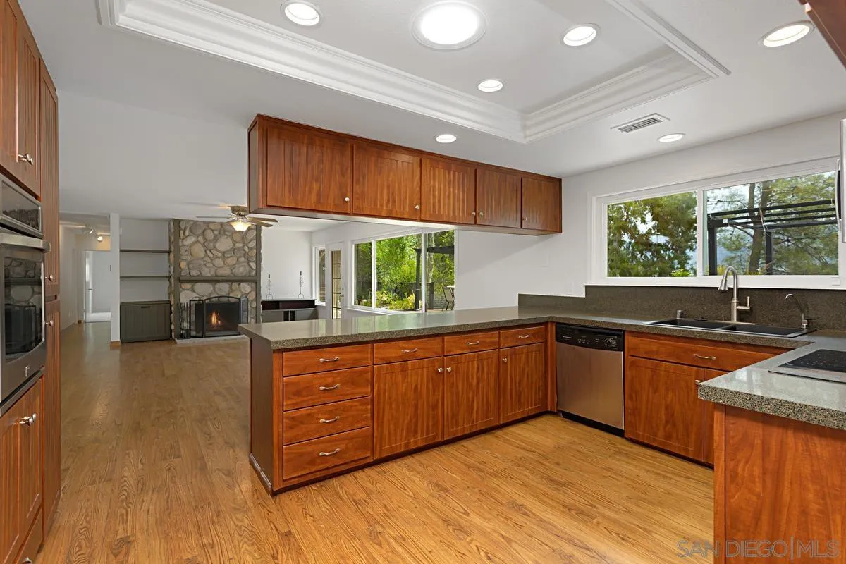 12759 Claire Drive Poway, CA 92064 - Photo 14 of 40 a kitchen with stainless steel appliances granite countertop wooden cabinets a sink dishwasher a stove and a refrigerator