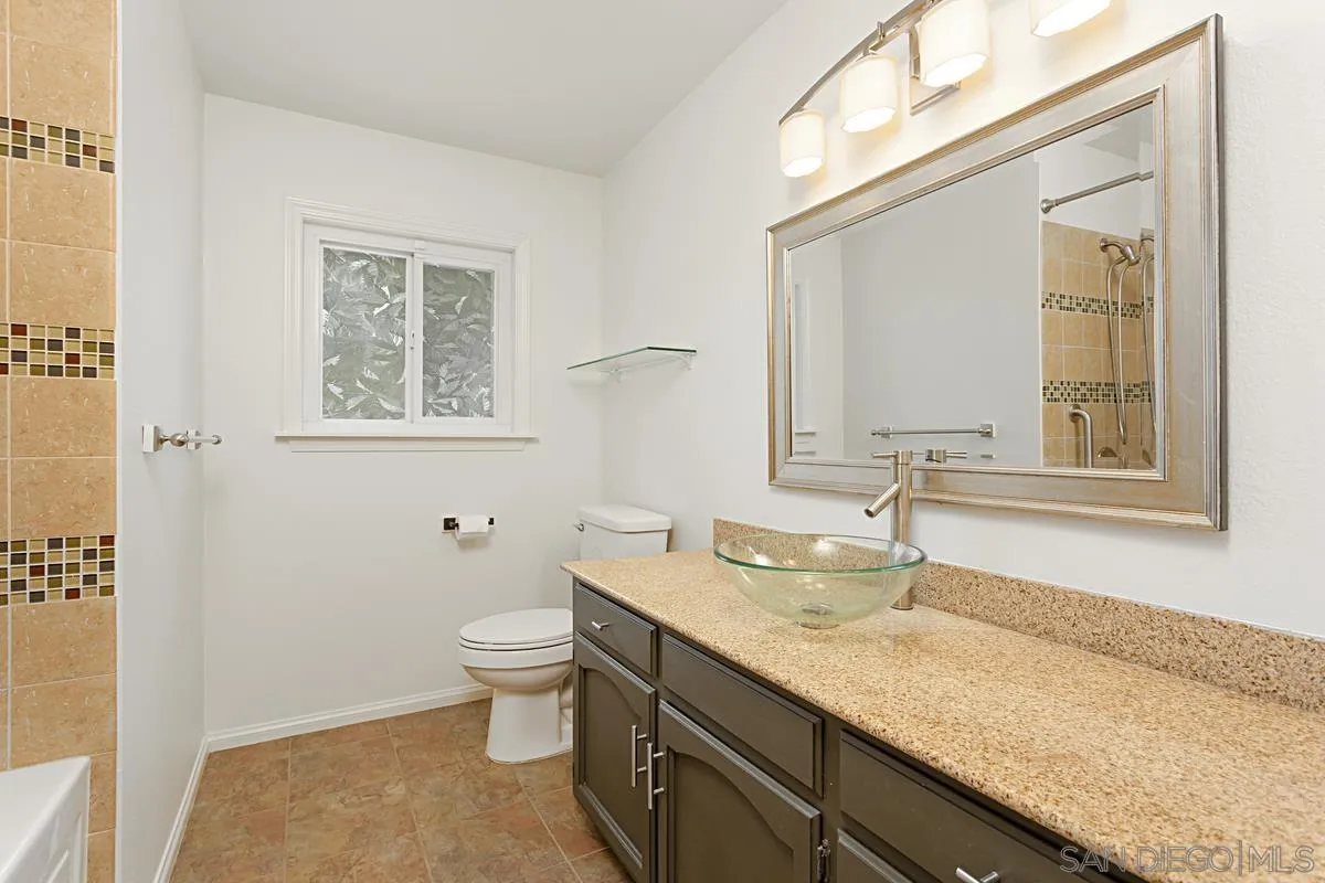 12759 Claire Drive Poway, CA 92064 - Photo 21 of 40 a bathroom with a granite countertop sink a toilet and a mirror