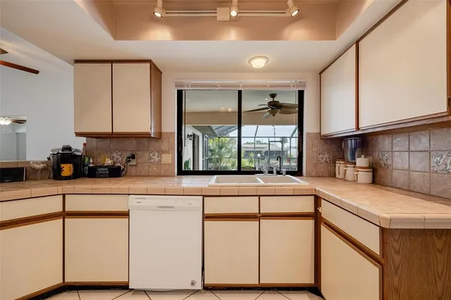 a kitchen with granite countertop white cabinets and white appliances