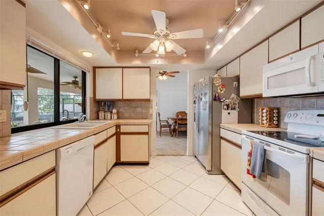 a kitchen with stainless steel appliances granite countertop a sink cabinets and wooden floor