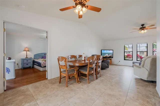 a dining room with furniture and a chandelier fan